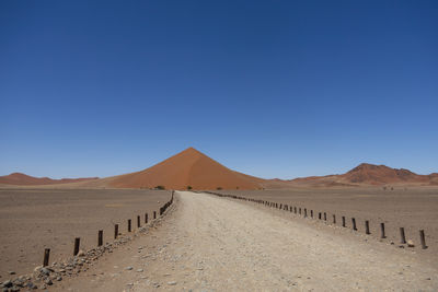 Scenic view of desert against clear blue sky