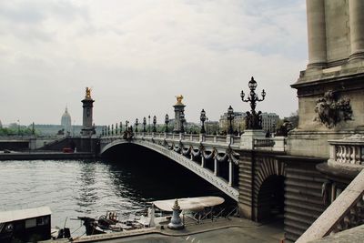 View of bridge over river against cloudy sky