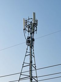 Low angle view of electricity pylon against clear sky