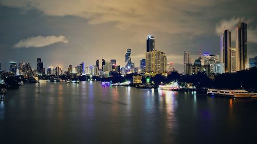 Illuminated buildings in city against sky