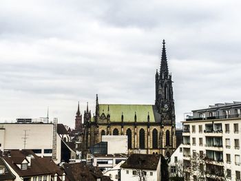 Buildings in city against cloudy sky