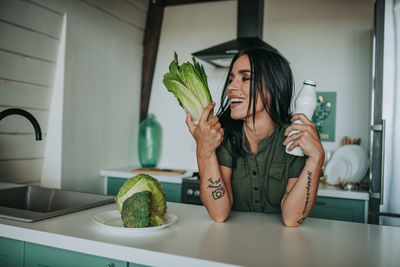 Woman with vegetables in kitchen at home