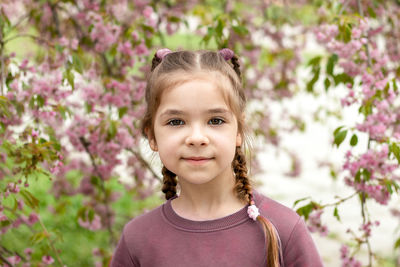 Portrait of young woman against plants