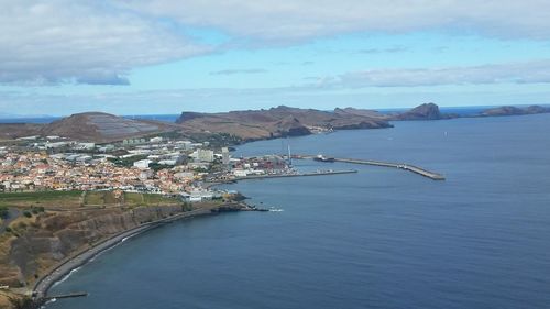 Scenic view of sea by town against sky