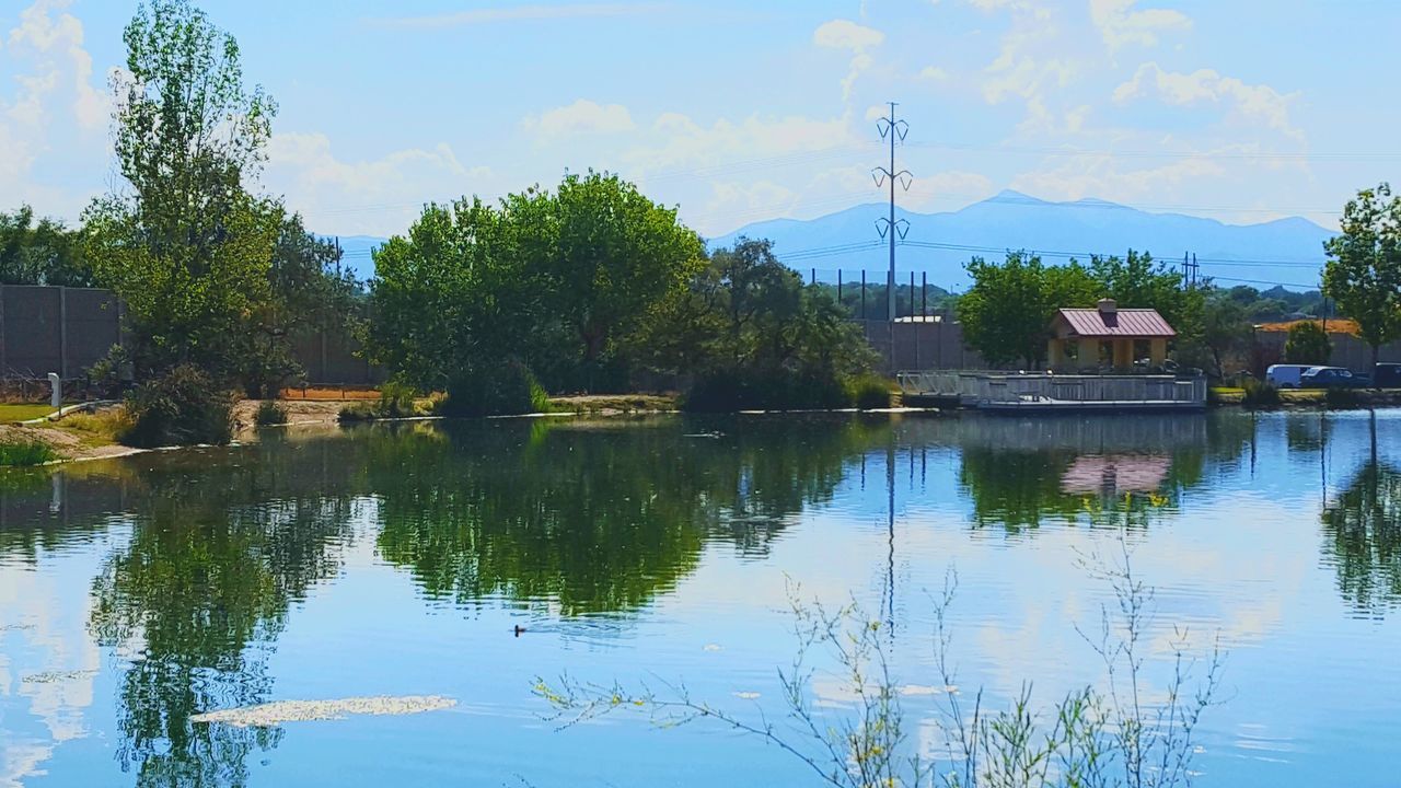 HOUSES BY LAKE AGAINST SKY