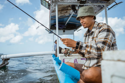 Rear view of man holding boat