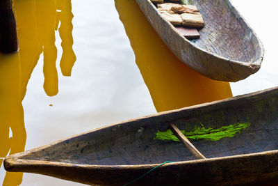 Close-up of rusty metal on wood by lake against sky