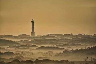 Lighthouse against sky during sunset