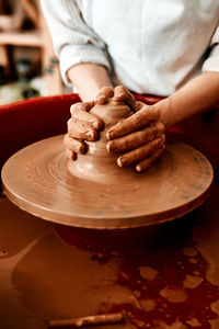 Midsection of man making pot