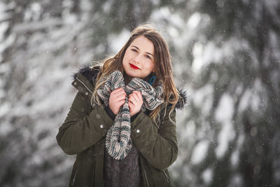 Young woman smiling in snow during winter