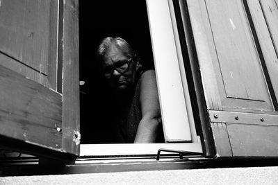 Portrait of man looking through window