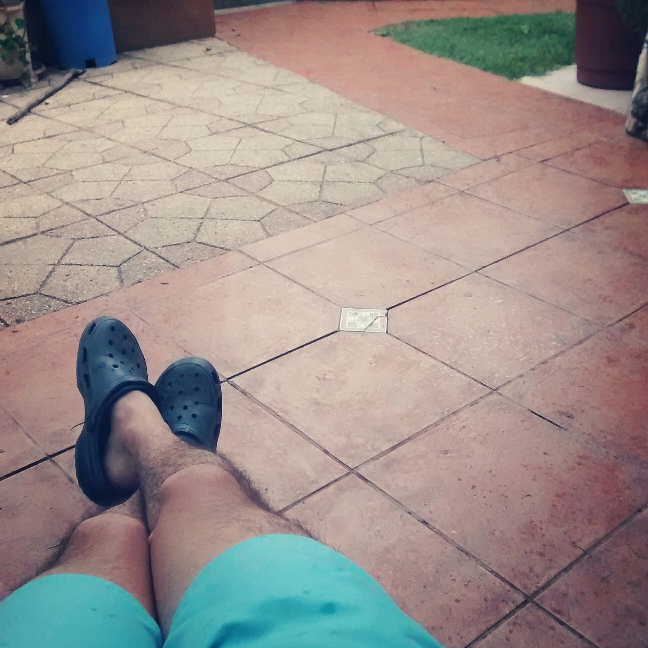 low section, person, high angle view, paving stone, tiled floor, cobblestone, shoe, flooring, footpath, standing, human foot, pattern, blue, sunlight, shadow, lifestyles, personal perspective, relaxation