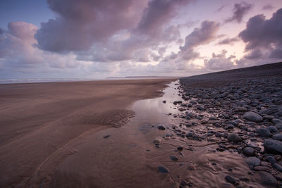 Scenic view of beach against sky during sunset