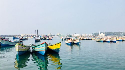 Boats moored in lake against clear sky