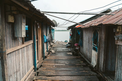 Narrow footpath amidst buildings against sky
