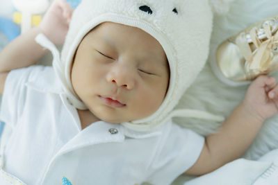 Cute baby boy sleeping on bed at home