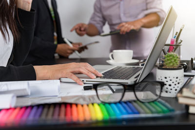 Midsection of business people working on table