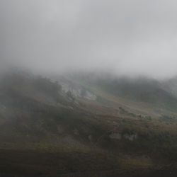 Scenic view of mountains against cloudy sky