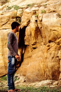 Rear view of man standing on rock