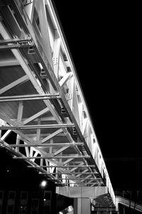 Low angle view of illuminated bridge at night