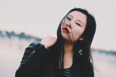 Beautiful young woman against sky