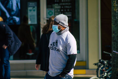 Full length of man using mobile phone on street in city