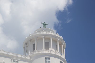 Low angle view of building against cloudy sky