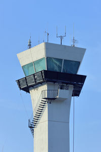 Low angle view of communications tower against clear blue sky