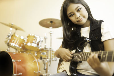 Portrait of a young woman playing guitar