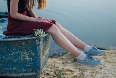 Low section of woman sitting on beach