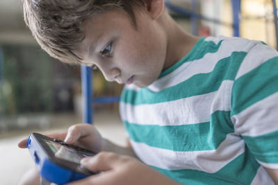 Side view of boy holding digital tablet