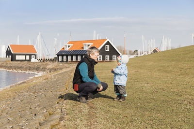 Side view of grandfather with granddaughter at lakeshore