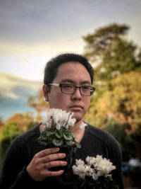 Portrait of young man holding flower