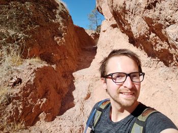 Portrait of smiling man standing on rock