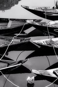 Sailboats moored at harbor