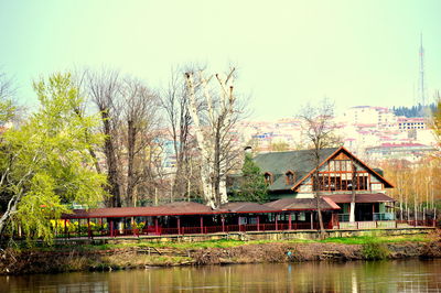 Lake by residential district against clear sky