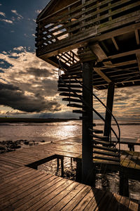 Pier over sea against sky during sunset