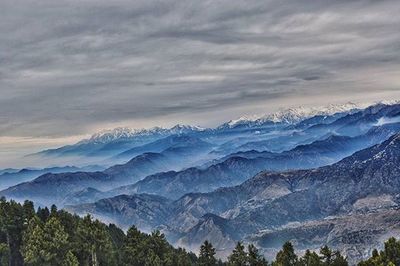 Scenic view of mountains against cloudy sky