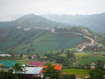 Aerial view of trees and houses on field against sky