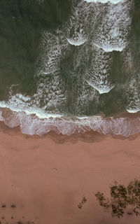 High angle view of sea waves on beach