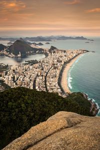 High angle view of cityscape by sea against sky