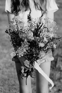 Close up of wild flower posy with teenager midsection