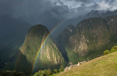 Scenic view of rainbow over mountains against sky