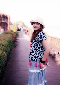 Portrait of smiling young woman standing in city