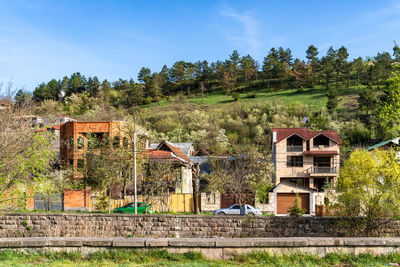 Houses by lake against sky