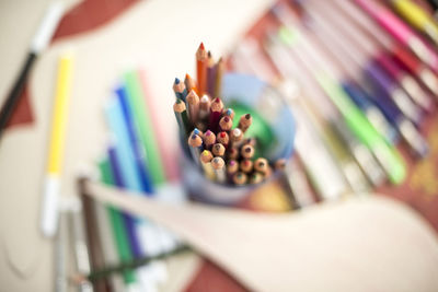 High angle view of colored pencils in desk organizer on table