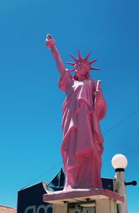 Low angle view of statue against clear blue sky