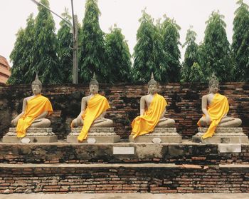 Sculpture of buddha statue against trees