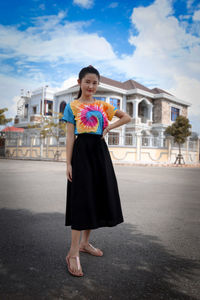 Portrait of smiling woman standing against building