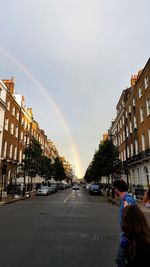 View of rainbow over road in city